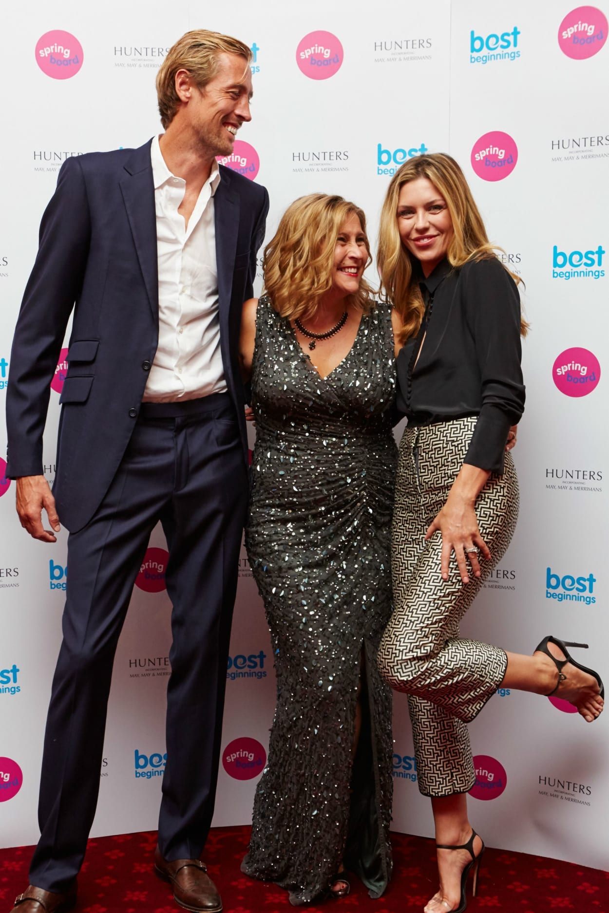 Footballer Peter Crouch (L) and his wife, model and TV presenter Abbey Clancey (R) share a joke with Best Beginnings CEO, Alison Baum, at the Springboard launch event.