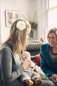 Vicki holding baby Jacob talking to Best Beginnings Chief Executive Alison Baum